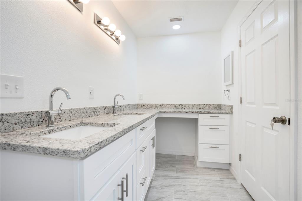 8448 Balm Street Weeki Wachee, FL 34607 - Photo 25 of 44 a bathroom with a granite countertop sink and a mirror