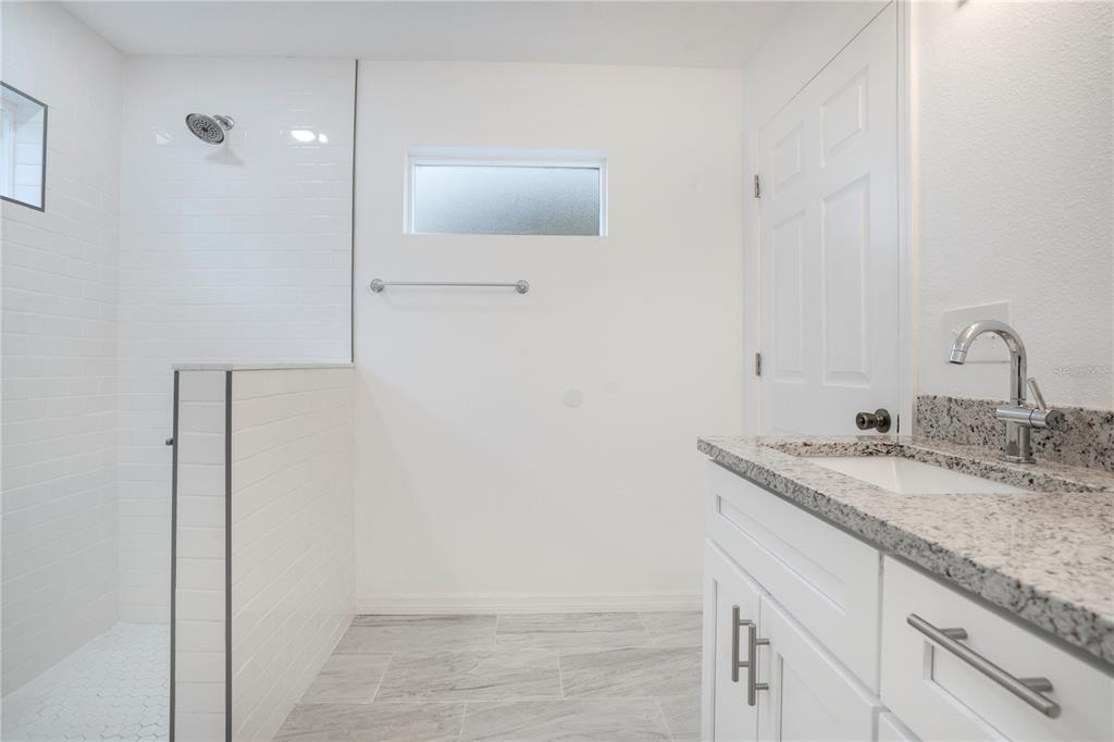 8448 Balm Street Weeki Wachee, FL 34607 - Photo 26 of 44 a bathroom with a granite countertop sink and a mirror