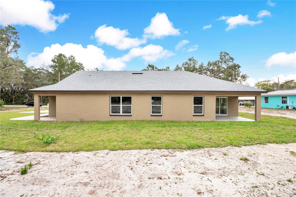8448 Balm Street Weeki Wachee, FL 34607 - Photo 32 of 44 a front view of a house with a garden and yard