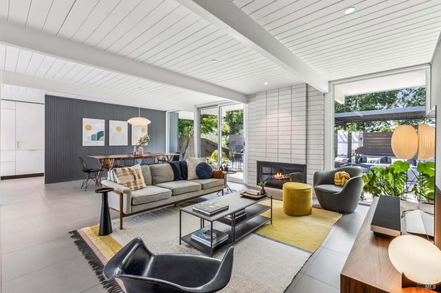 a living room with furniture fireplace and a large window