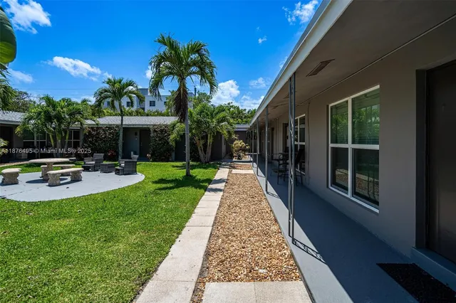 a view of a house with backyard and sitting area