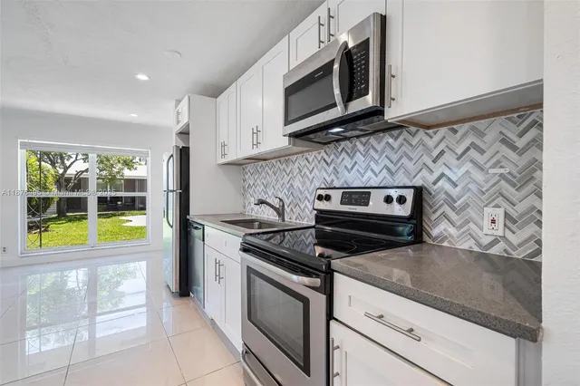 a kitchen with stainless steel appliances a refrigerator sink and stove