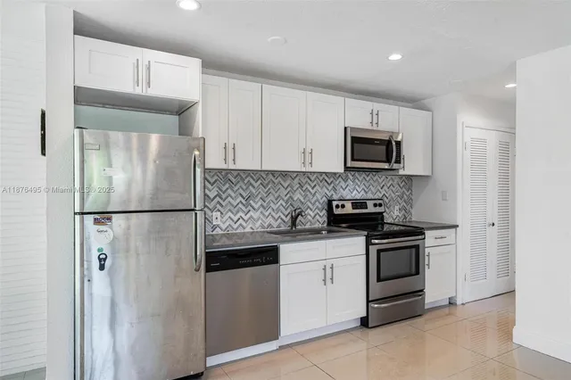 a kitchen with stainless steel appliances a refrigerator and a stove top oven