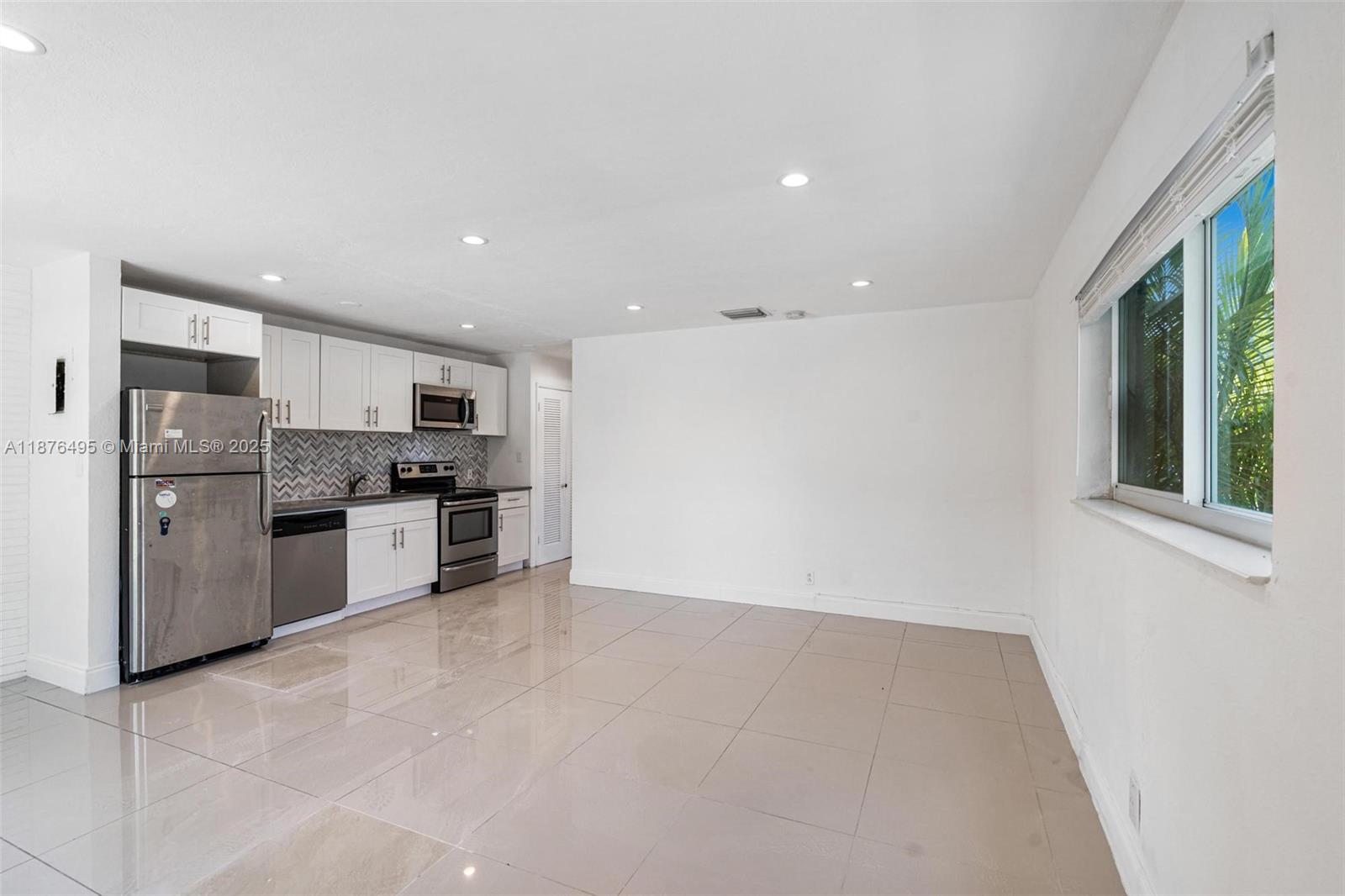 2201 Northeast 14th Avenue, Unit 9 Wilton Manors, FL 33305 - Photo 25 of 30 a kitchen with stainless steel appliances a refrigerator and a stove top oven