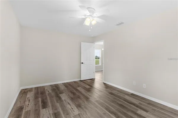 a view of a room with wooden floor and a ceiling fan