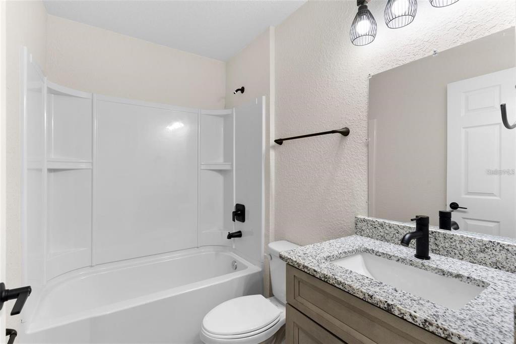 328 Eucalyptus Road Lake Wales, FL 33898 - Photo 17 of 18 a bathroom with a granite countertop sink toilet tub and shower