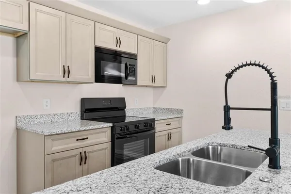 a kitchen with granite countertop a sink and a stove top oven with granite countertops