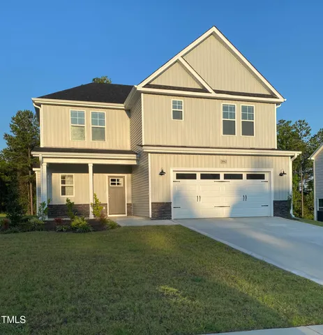 a front view of a house with a yard and trees