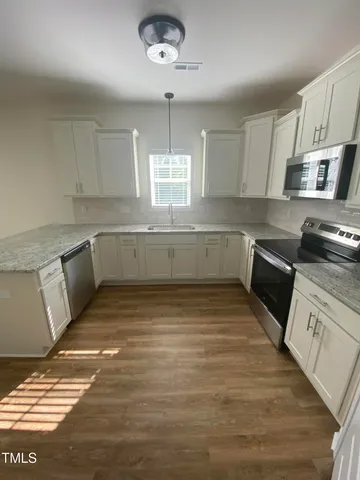 a large kitchen with stainless steel appliances granite countertop a sink and a stove