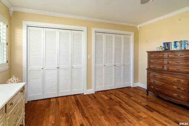 a view of a bedroom with wooden floor and cabinet