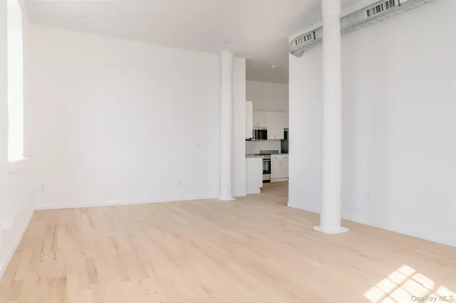 a view of empty room with wooden floor