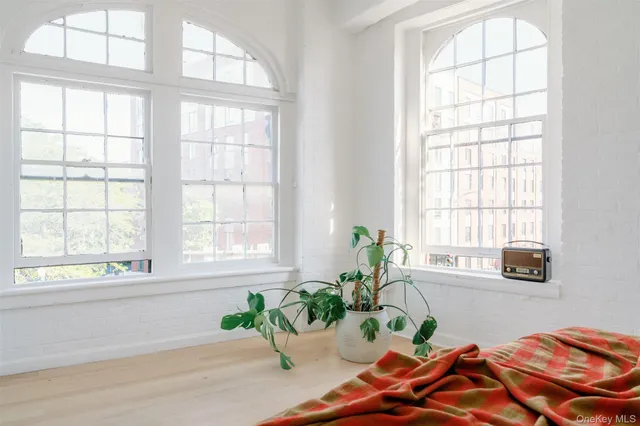 a white bed sitting in a bedroom next to a window