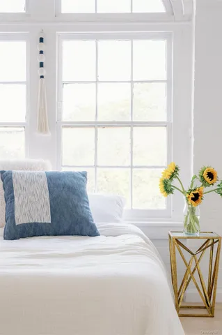 a large bed sitting in a bedroom next to a window