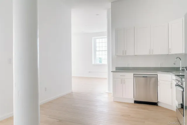 a kitchen with granite countertop white cabinets and white appliances