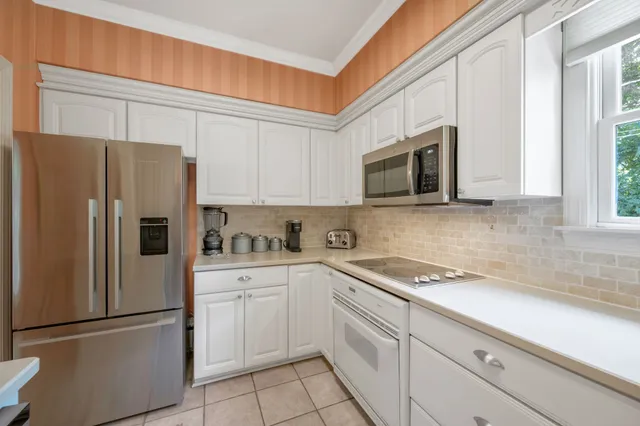 a kitchen with stainless steel appliances white cabinets white and a refrigerator