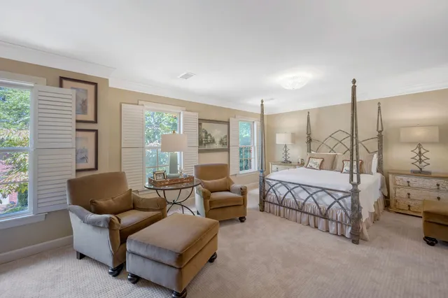 a spacious bedroom with a bed a couch and large window