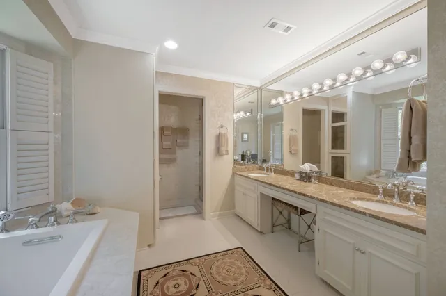 a bathroom with a granite countertop sink a mirror and a bathtub