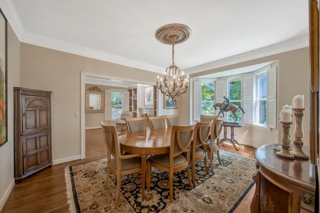 a view of a dining room with furniture a chandelier and wooden floor