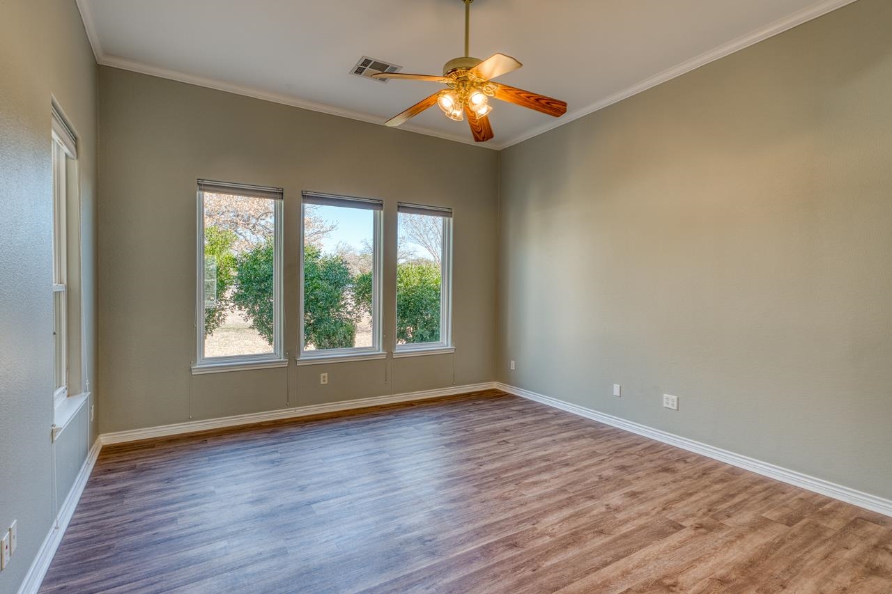 2804 Oak Ridge Drive Horseshoe Bay, TX 78657 - Photo 16 of 30 a view of an empty room with wooden floor and a window