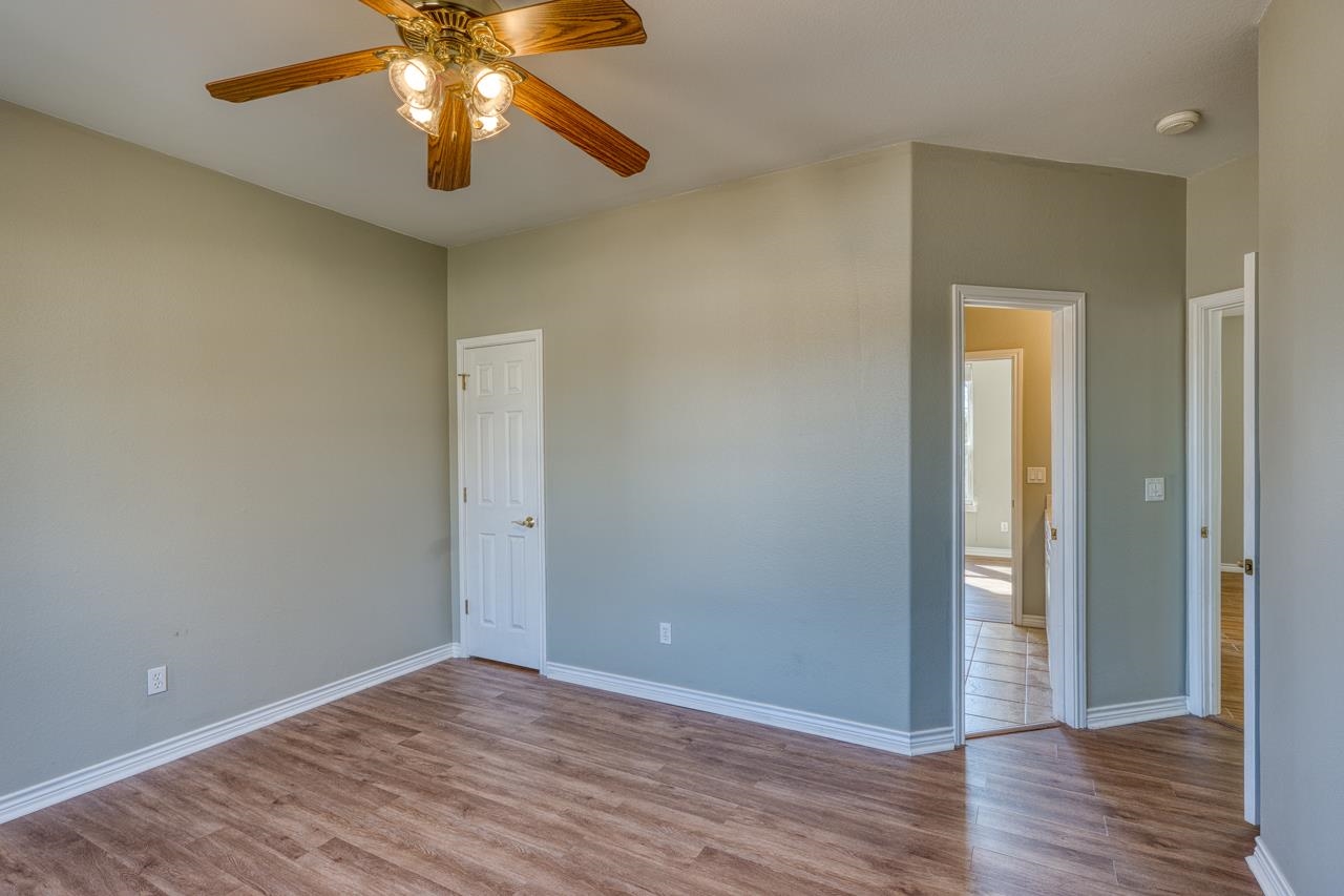 2804 Oak Ridge Drive Horseshoe Bay, TX 78657 - Photo 18 of 30 a view of an empty room with wooden floor and a chandelier fan