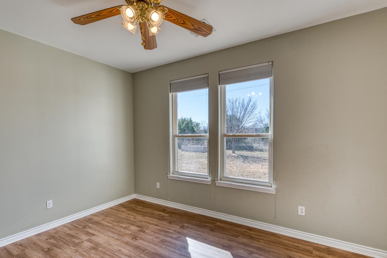 2804 Oak Ridge Drive Horseshoe Bay, TX 78657 - Photo 20 of 30 a view of an empty room with wooden floor and a window