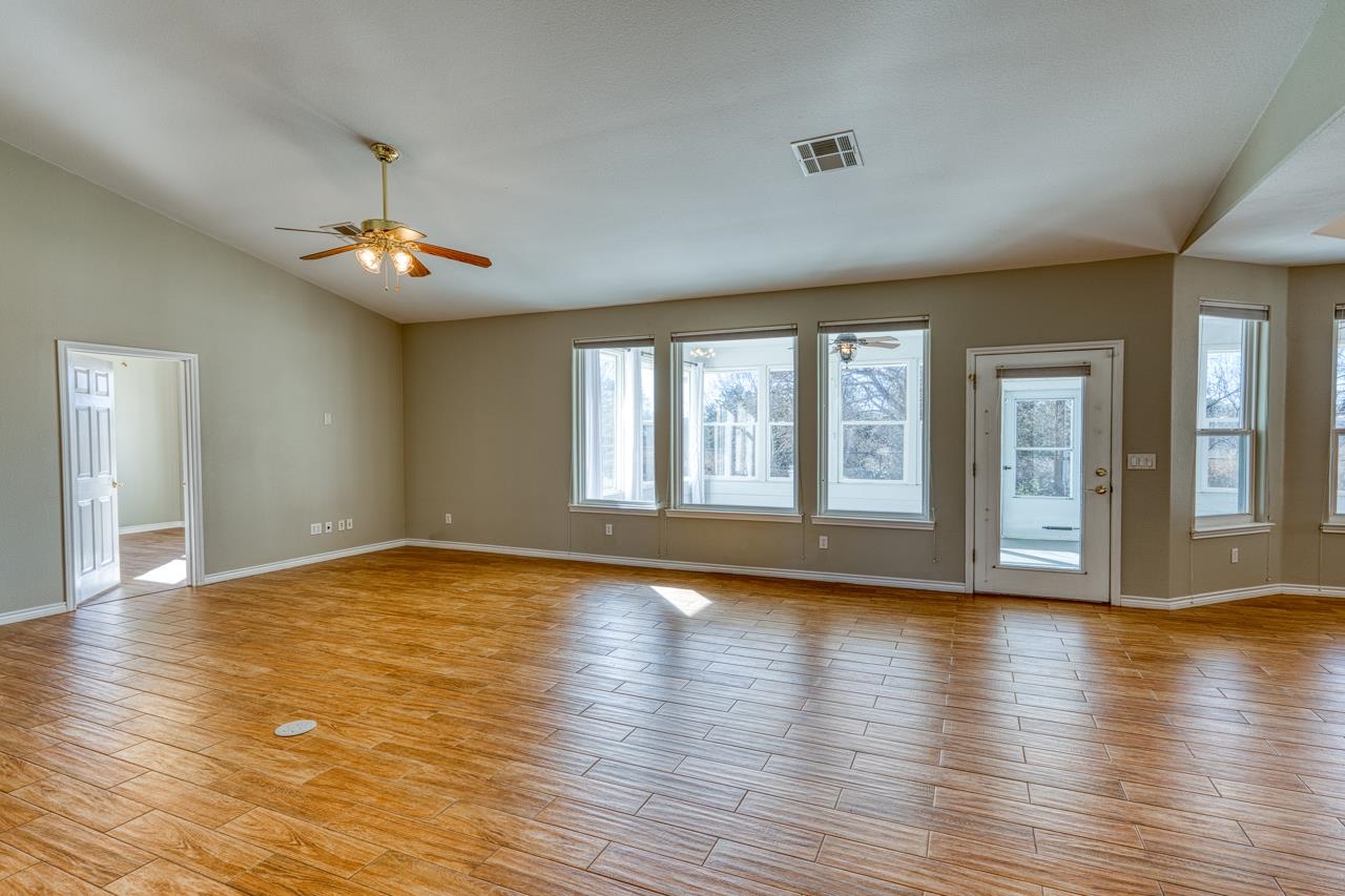 2804 Oak Ridge Drive Horseshoe Bay, TX 78657 - Photo 5 of 30 a view of an empty room with wooden floor and a window