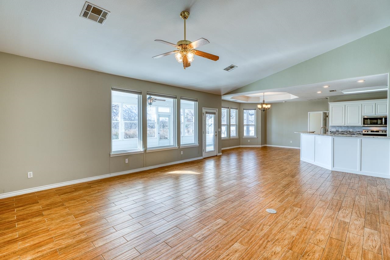 2804 Oak Ridge Drive Horseshoe Bay, TX 78657 - Photo 6 of 30 a view of an empty room with wooden floor and a window