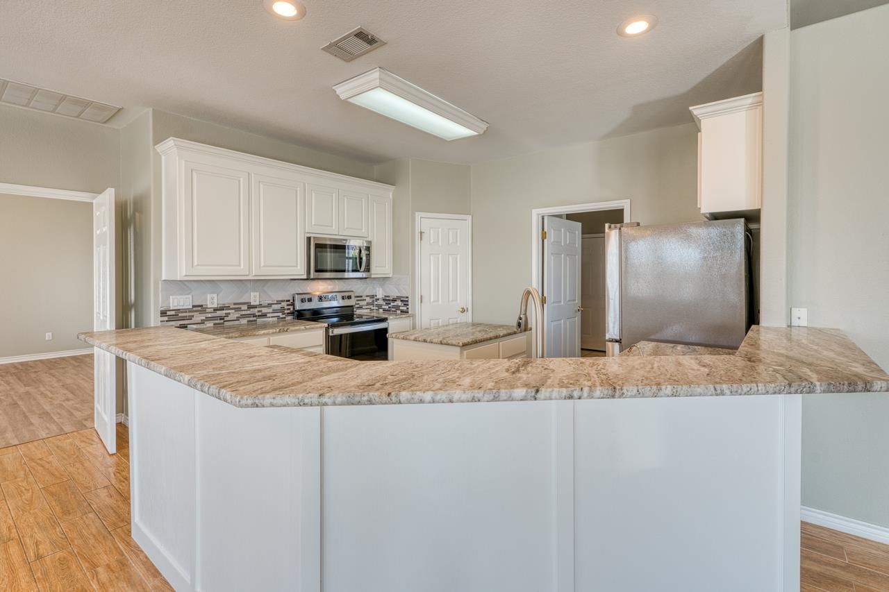 2804 Oak Ridge Drive Horseshoe Bay, TX 78657 - Photo 10 of 30 a kitchen with stainless steel appliances granite countertop a refrigerator a stove and a sink