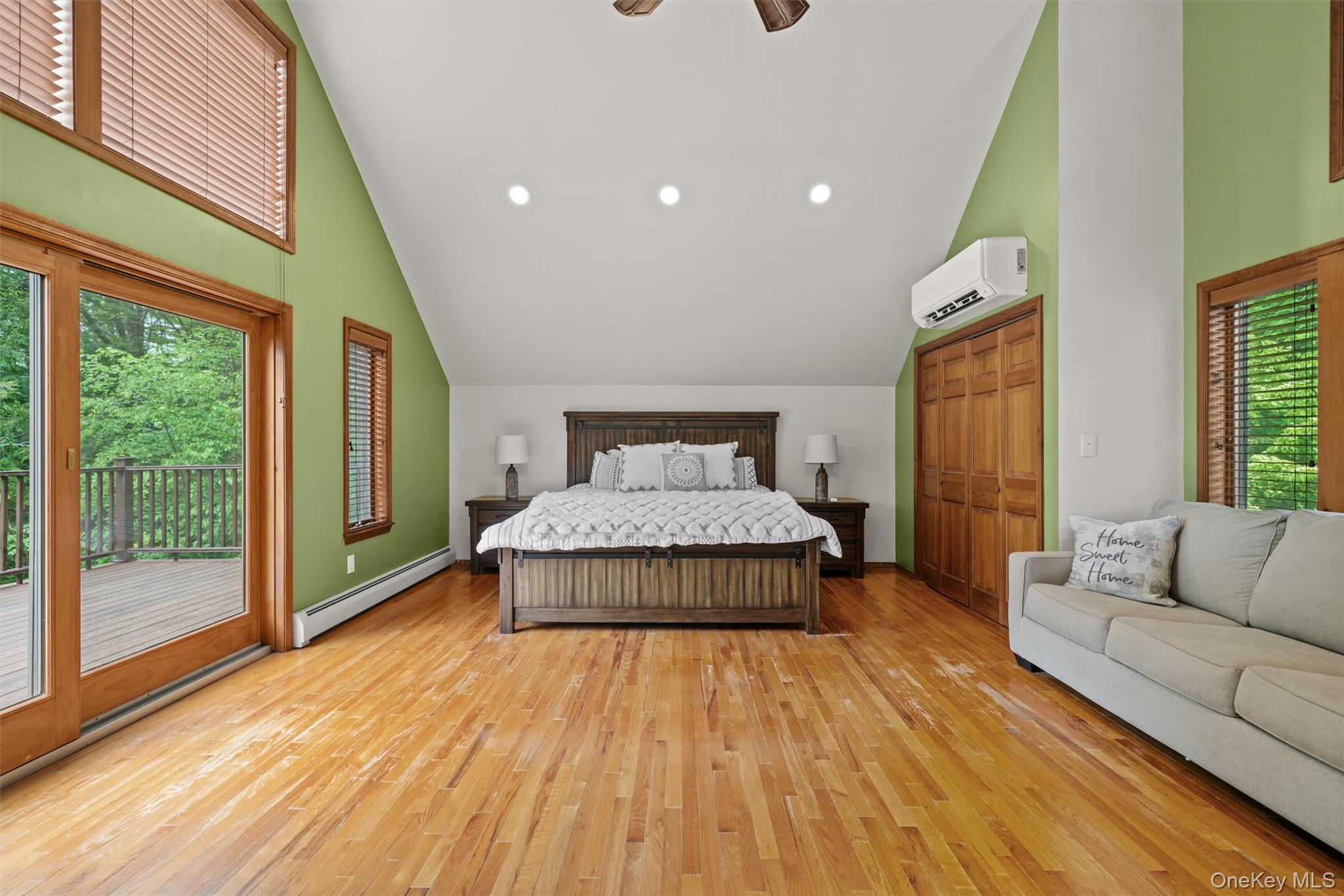 1775 Plank Rd Section A Forestburgh, NY 12777 - Photo 17 of 50 Bedroom featuring baseboard heating, access to exterior, a wall mounted AC, light wood finished floors, and high vaulted ceiling