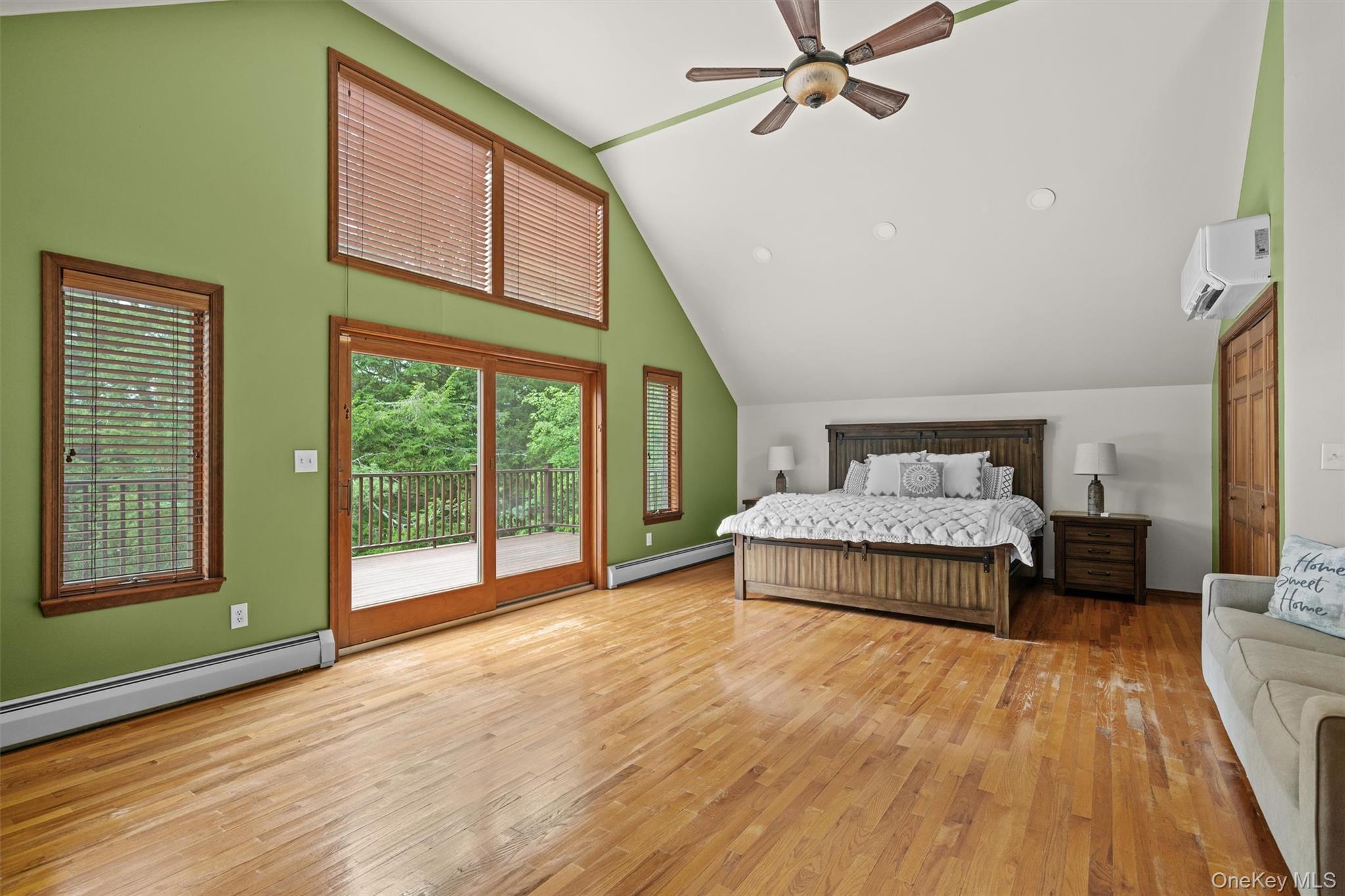 1775 Plank Rd Section A Forestburgh, NY 12777 - Photo 18 of 50 Bedroom with a wall mounted air conditioner, access to exterior, a baseboard radiator, wood finished floors, and high vaulted ceiling