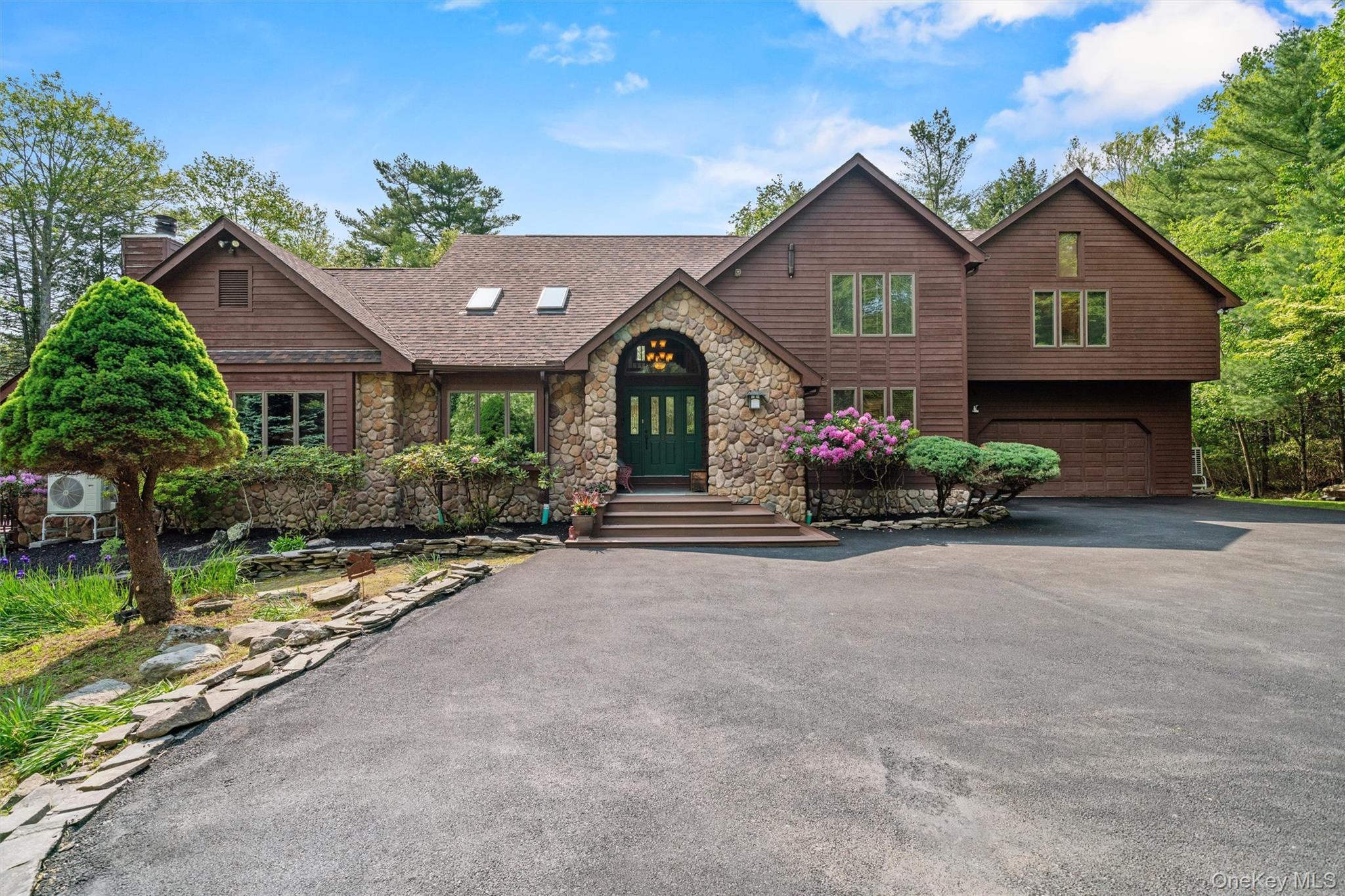 1775 Plank Rd Section A Forestburgh, NY 12777 - Photo 3 of 50 View of front facade with stone siding, a garage, asphalt driveway, a chimney, and a shingled roof