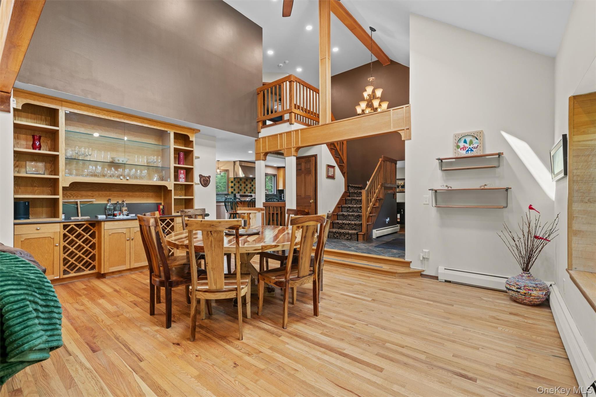 1775 Plank Rd Section A Forestburgh, NY 12777 - Photo 8 of 50 Dining area with light wood-style flooring, a baseboard radiator, stairway, bar area, and high vaulted ceiling