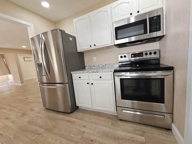 a kitchen with stainless steel appliances a stove a microwave and a refrigerator