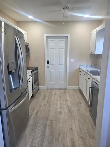 a kitchen with stainless steel appliances granite countertop a refrigerator and a stove