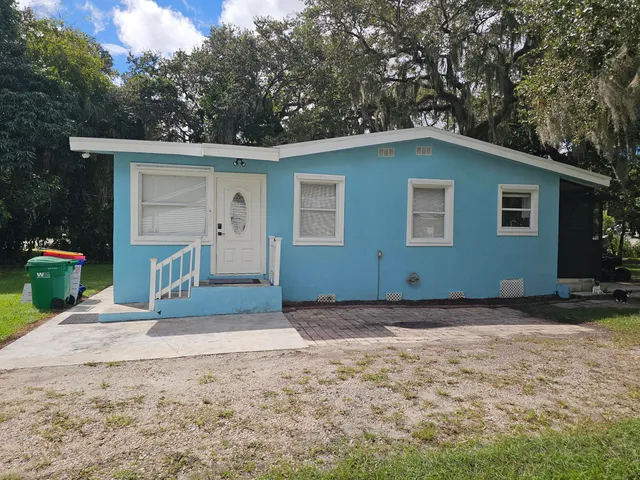 a view of house with backyard space and tree