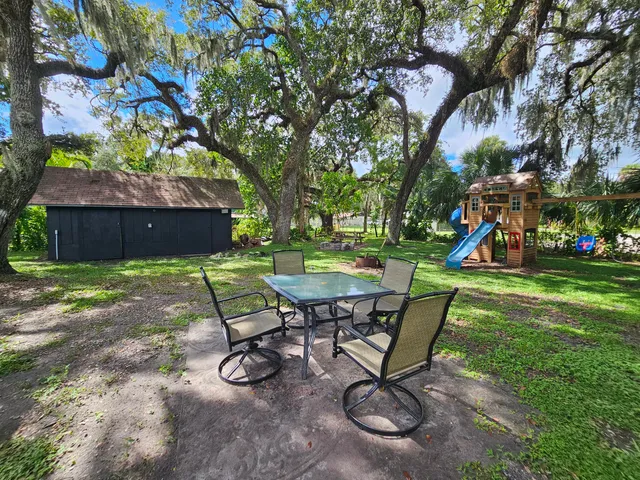 a backyard of a house with lots of green space and fountain