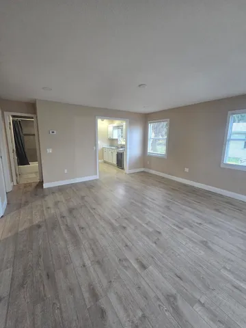 a view of a livingroom with wooden floor and window