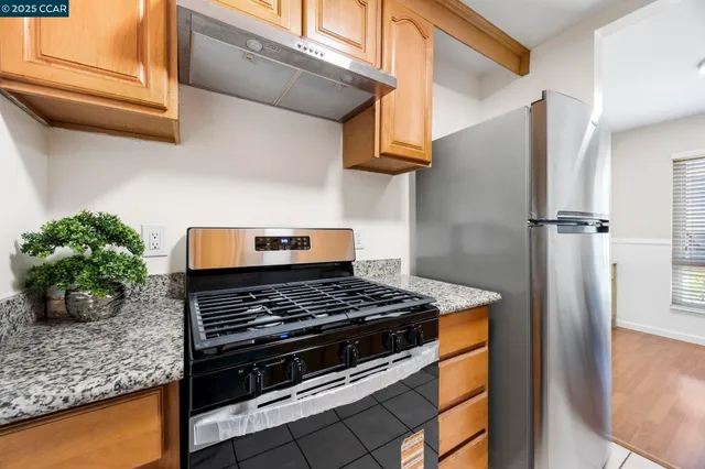 a kitchen with stainless steel appliances granite countertop a stove and a refrigerator