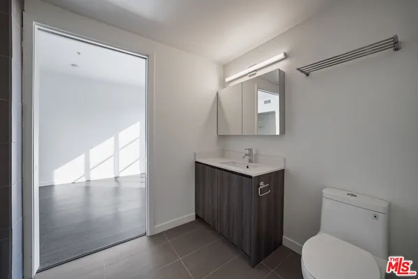 a bathroom with a toilet a sink and mirror