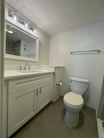 a bathroom with a toilet sink and mirror
