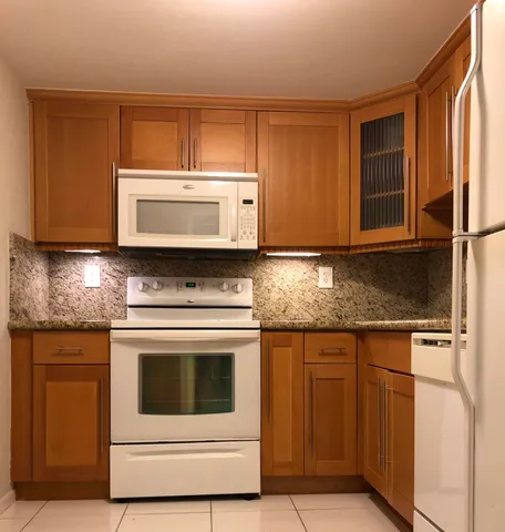 a stove top oven sitting inside of a kitchen