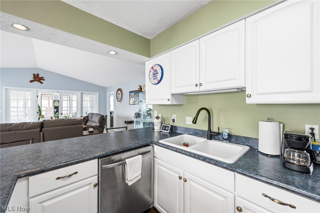 5352 Jaycox Road North Ridgeville, OH 44039 - Photo 8 of 27 Kitchen featuring stainless steel dishwasher, sink, lofted ceiling, and white cabinetry