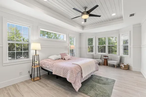 a bedroom with a large bed and wooden floor
