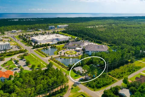 an aerial view of residential house with outdoor space and trees all around
