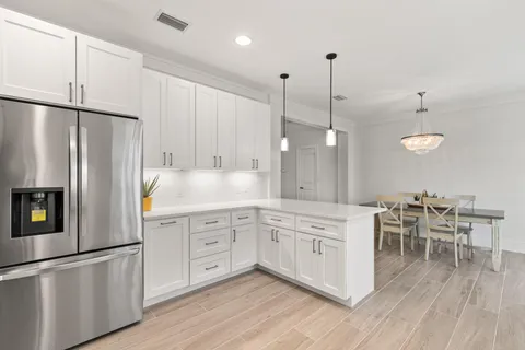 a kitchen with white cabinets and stainless steel appliances