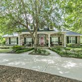 a front view of a house with a yard and green space