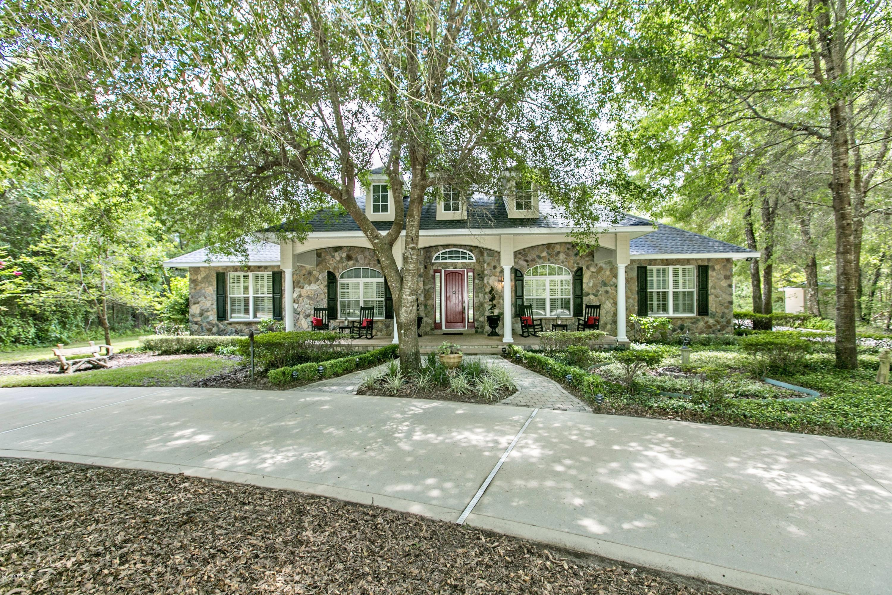 a front view of a house with a yard and green space