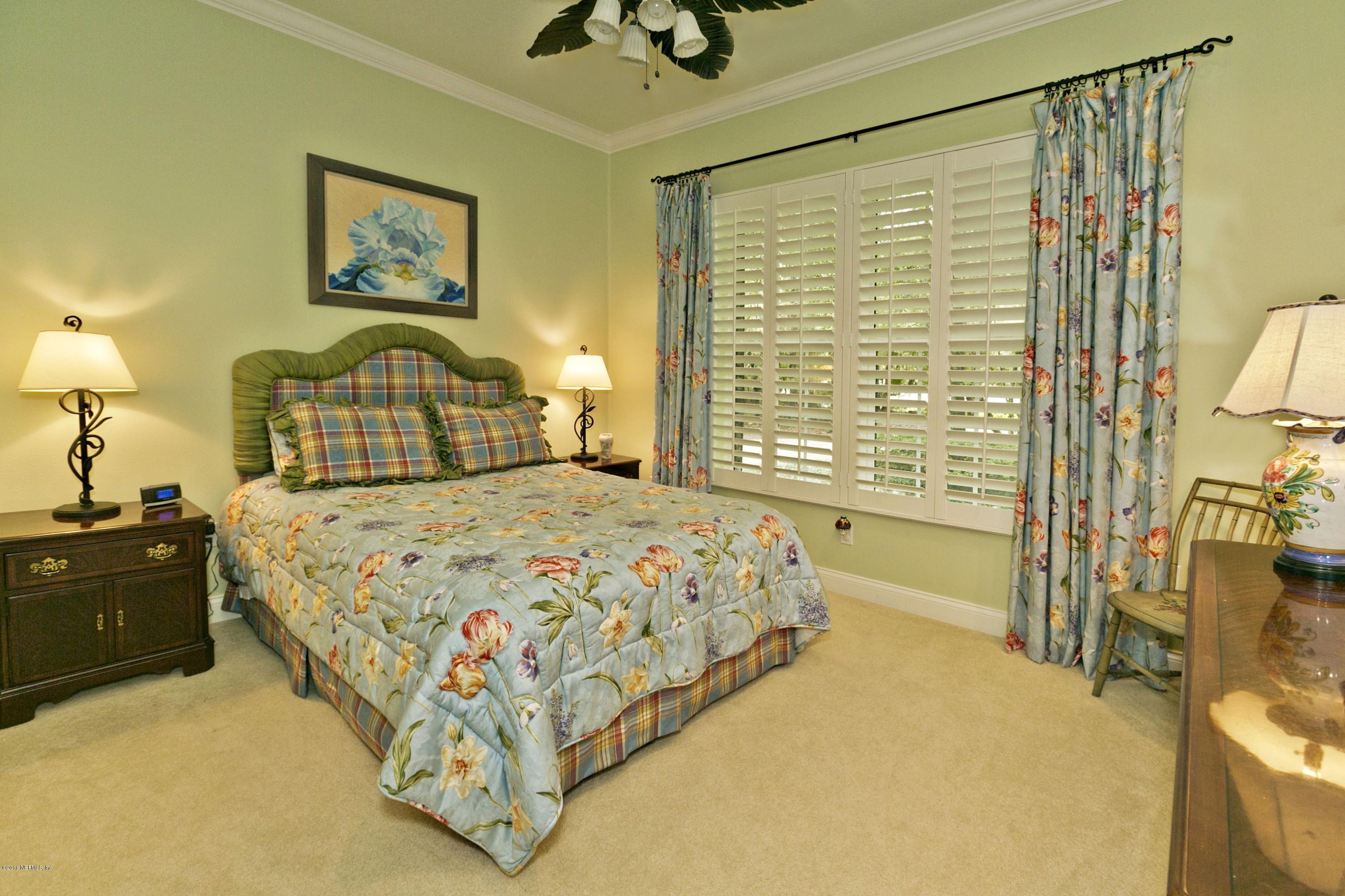 120 Dancing Horse Drive Hastings, FL 32145 - Photo 23 of 65 a bedroom with a bed and a chandelier