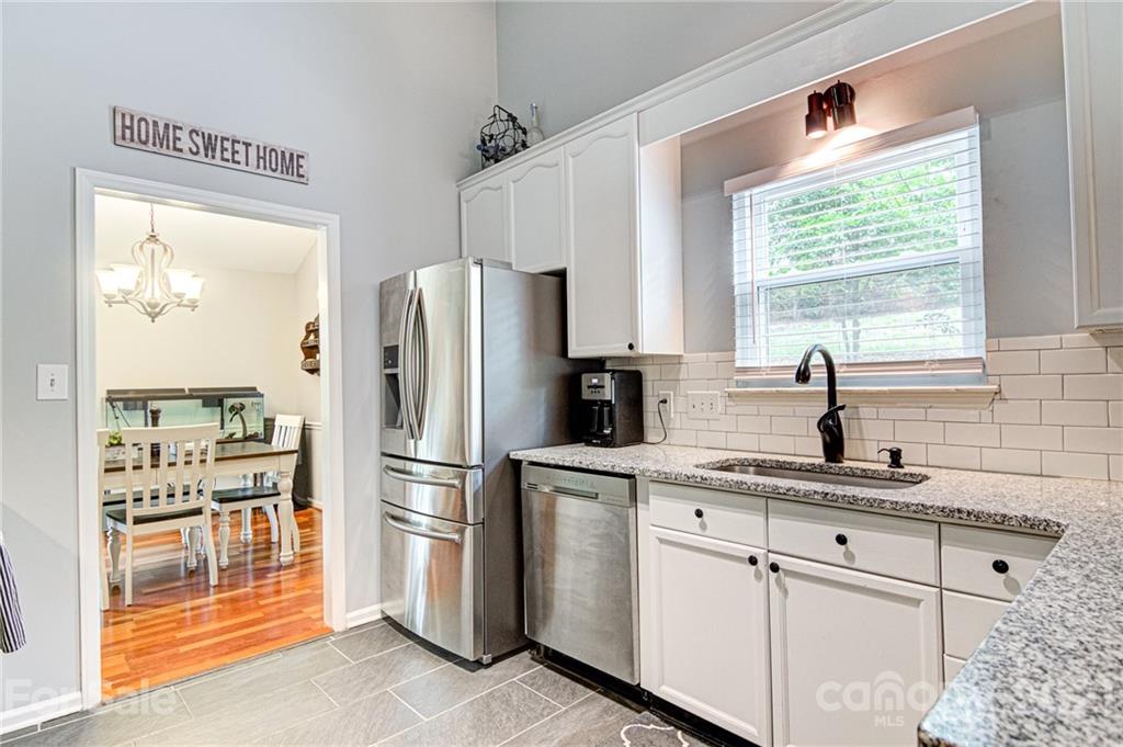 10715 Spruce Mountain Road Charlotte, NC 28214 - Photo 13 of 33 a kitchen with white cabinets and window