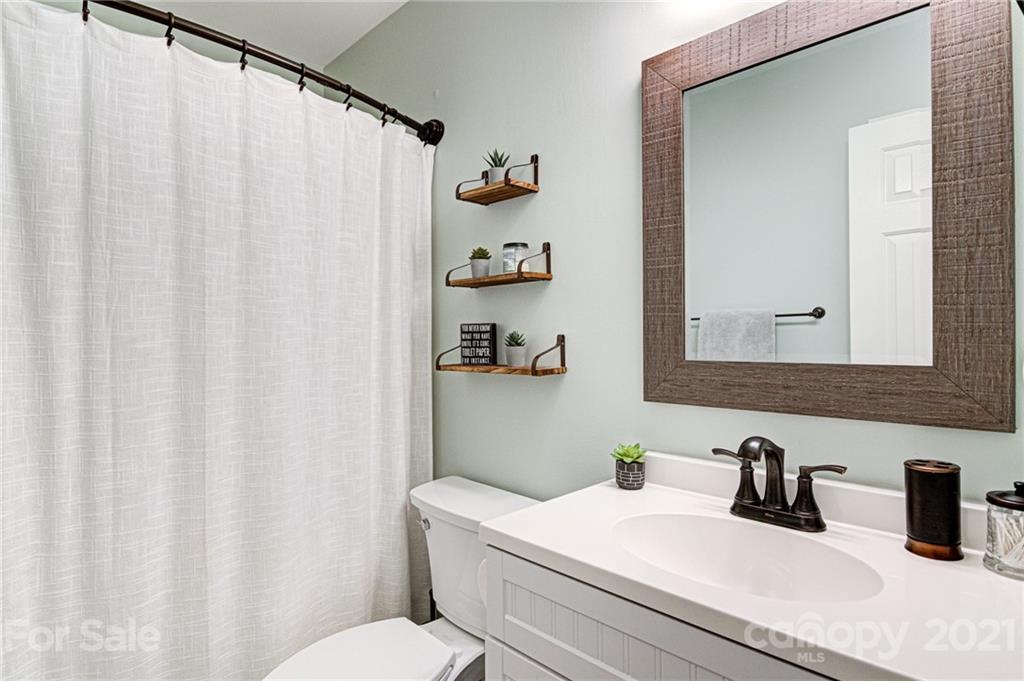 10715 Spruce Mountain Road Charlotte, NC 28214 - Photo 27 of 33 a bathroom with a sink a toilet and a mirror